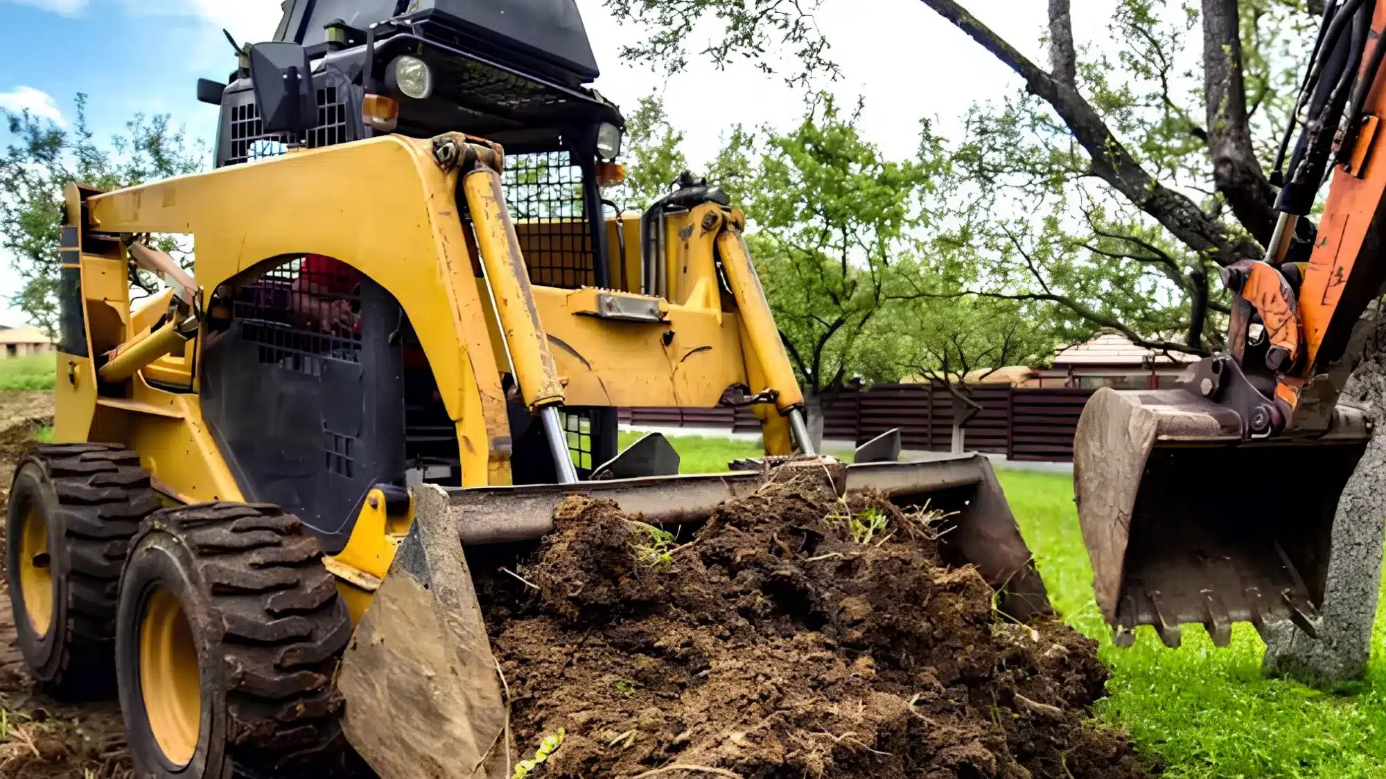 Land clearing equipment removing trees, brush, and overgrowth from a residential property to prepare land for construction, landscaping, or development